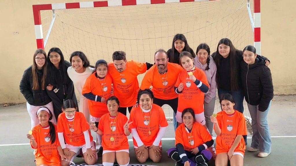 Jugadoras, entrenadores y familias de Athletic Futsal celebrando juntos en la pista